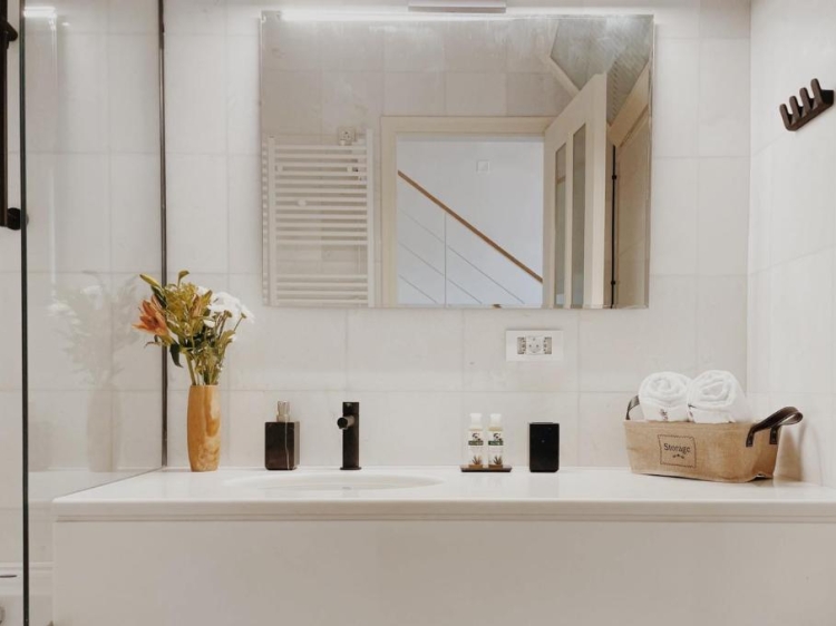 Baño, lavabo, espejo, toallas, flores