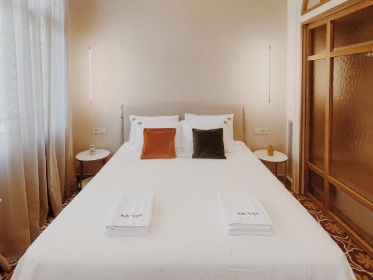 Cama doble, almohadas, mesas laterales, luces colgantes, diseño moderno