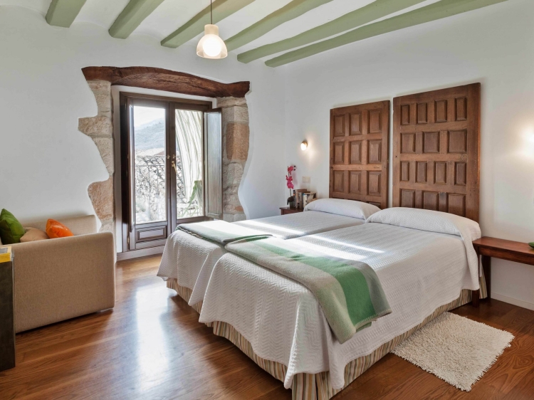  Casa La Rinconada en Azuelo Navarra ofrece una espaciosa casa de vacaciones con tres dormitorios y dos baños. El salón cuenta con un sofá y suelos de parqué, proporcionando un espacio cómodo para relajarse.