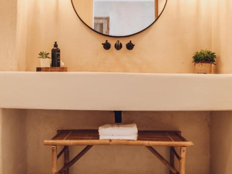Natural stone sinks, open space design, raw wood accents, round mirror